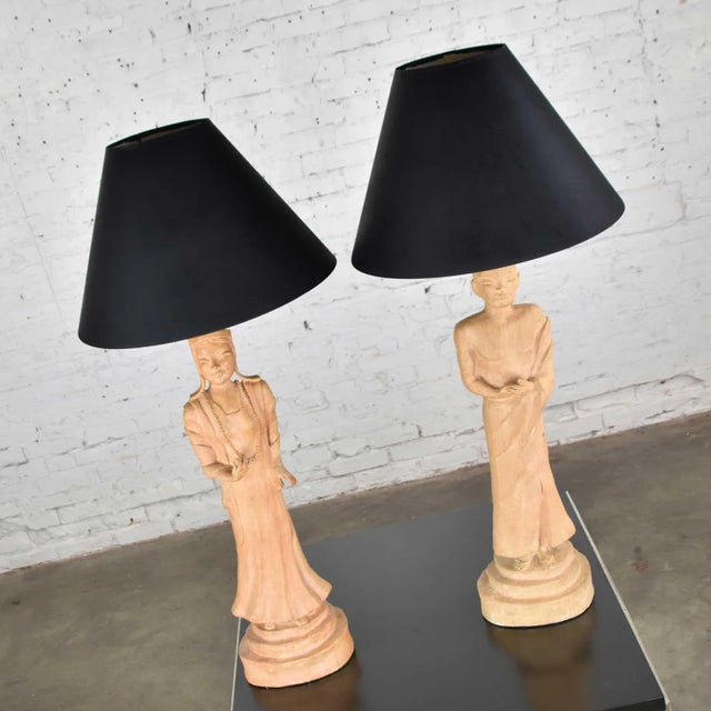 Handsome pair of Hollywood Regency Asian female and male figural lamps in the style of James Mont wearing black hard...