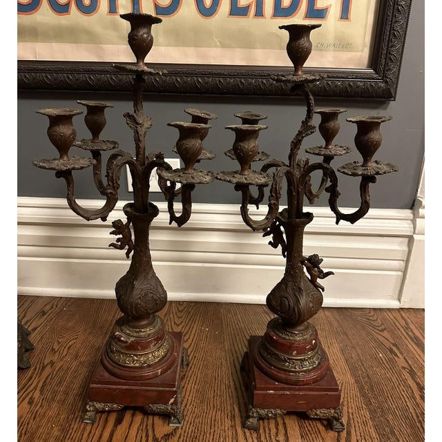 Don't miss out on this exquisite pair of 19th Century French patinated bronze spelter and rouge griotte marble candelabras...