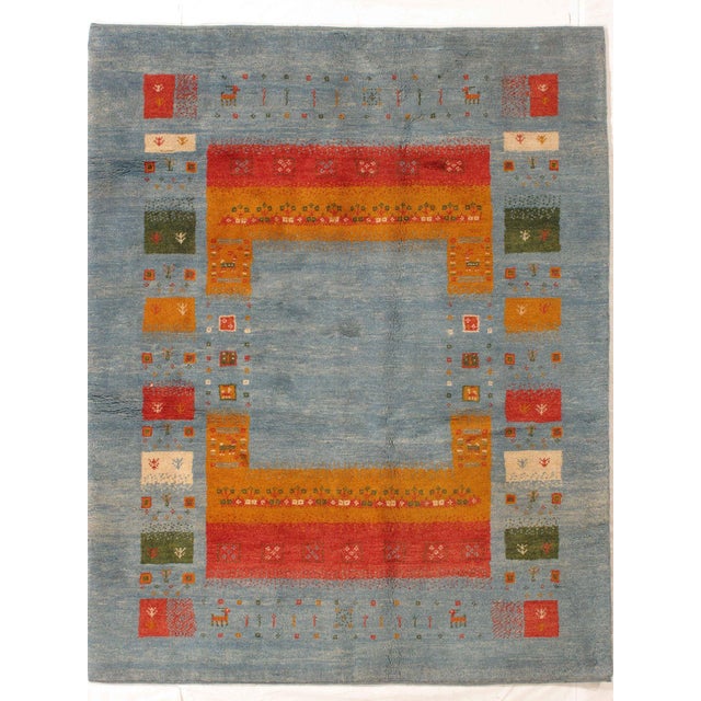 Vintage Hand-knotted Persian Lori Gabbeh rug featuring a soft blue field enclosed by a structured, multicolored geometric...