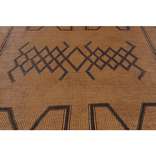 Made with handwoven reed and camel leather in Mauritania circa 1950-1960, this 8x16 vintage Tuarage runner mat is an...