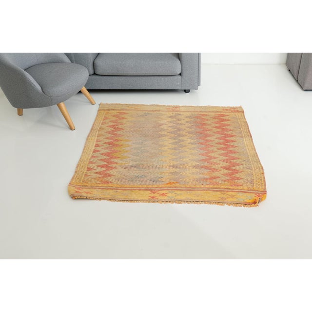 This is a vintage Turkish Oushak rug from the Mid 20th Century. The piece was hand-knotted.