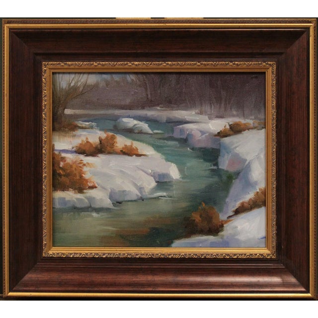 The painting depicts a serene landscape featuring a gently winding creek surrounded by soft, golden grasses and muted...