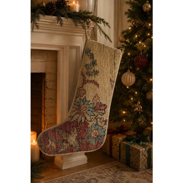This vintage wool kilim stocking pairs a soft, understated cream leg with a bold burst of red and teal star motifs...
