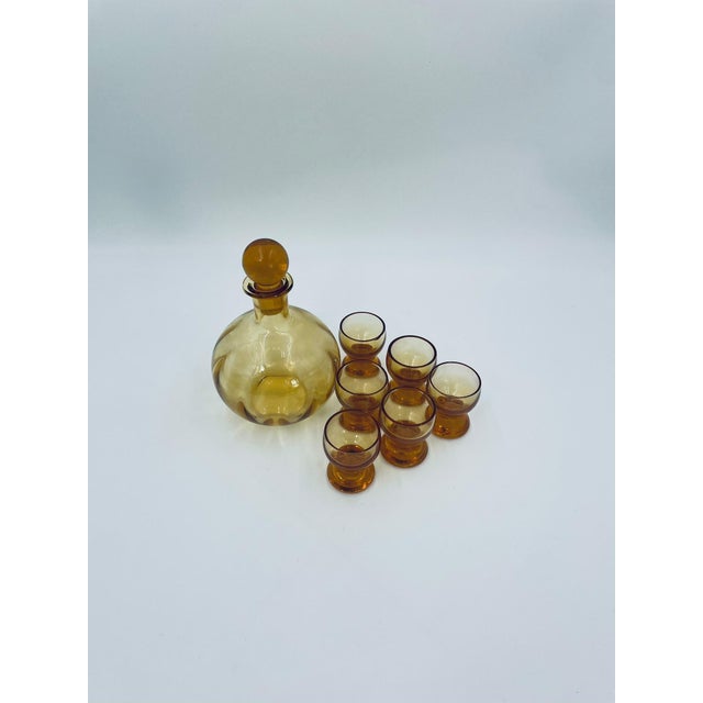 A set of Art Deco-style liqueur decanters and glasses, crafted from high-quality glass. The set features a distinctive...