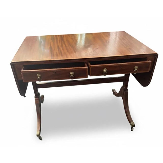 Regency-Style Flame Mahogany Drop-Leaf Sofa Table with Brass Lion Pulls A highly elegant and versatile Regency-style drop-...