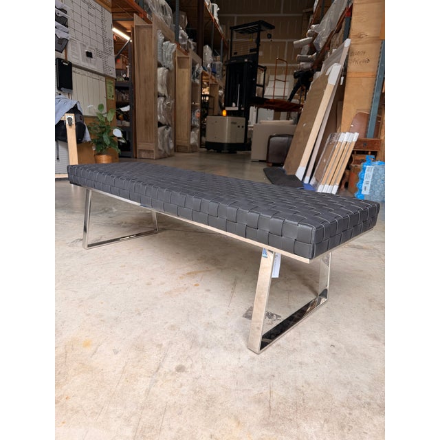 Sleek and modern, this contemporary bench features a black leather upholstered seat paired with polished chrome legs for a...