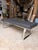 Sleek and modern, this contemporary bench features a black leather upholstered seat paired with polished chrome legs for a...