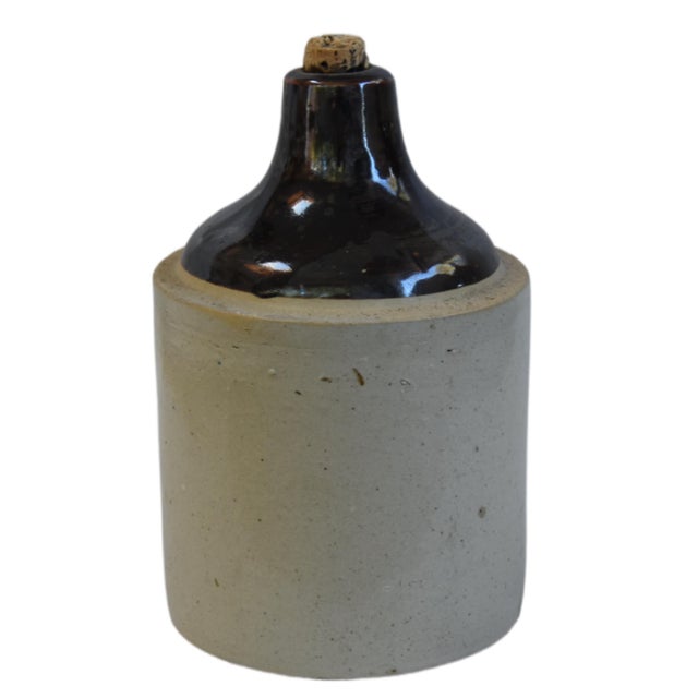 Beautifully balanced antique stoneware jug with a two-tone design, featuring a rich, dark brown Albany slip-glazed upper...