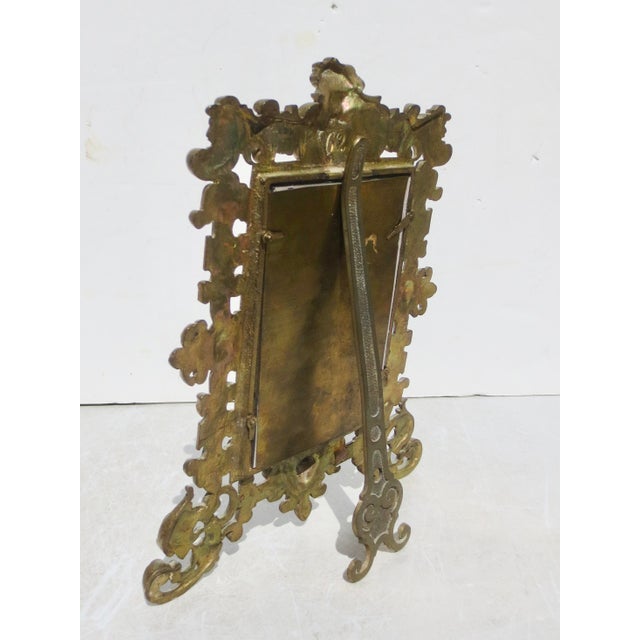 Gothic-style brass photo frame. The measurements are 10.75" and 8.5" wide. The window is 5.5" by 3.75". Cast in deep...