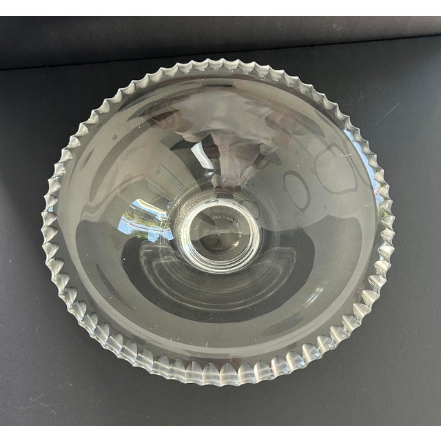 This elegant glass bowl features characteristic mid-century modern design elements, specifically the deeply molded, ribbed...