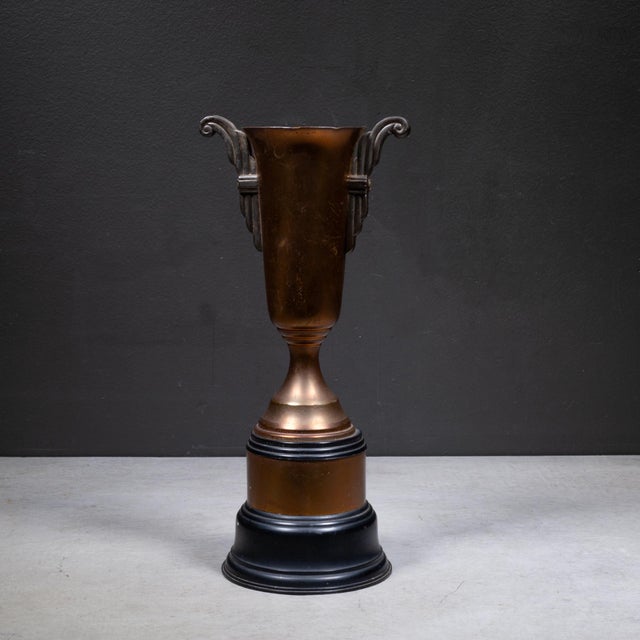 ABOUT An original Art Deco brass and copper plated cup trophy with a Bakelite base. Original metal maker's tag. CREATOR...