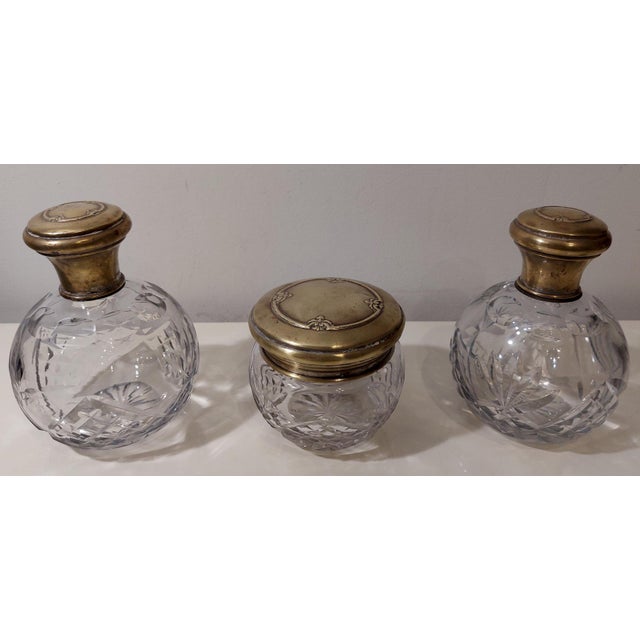 Vintage Art Deco crystal and silver vanity set from the 1920s. This three-piece set of cut crystal vanity pieces is...