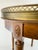 A beautiful vintage Louis XVI-style side table featuring a warm mahogany frame, inset cream marble top, and beautifully...