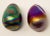 Offering a unique pair of art glass eggs. Both are iridescent, one having greens and blues, and the other is magenta and...