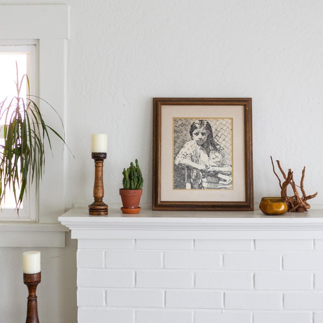 An early 20th-century pen and ink portrait of a young girl wearing a checkered flannel, facing the viewer with a strong,...