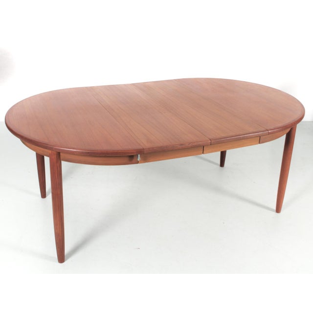Rosengren Hansen round teak dining table, extendable for 4 to 10 people. Tapered T-shaped legs. Square headband. 2...