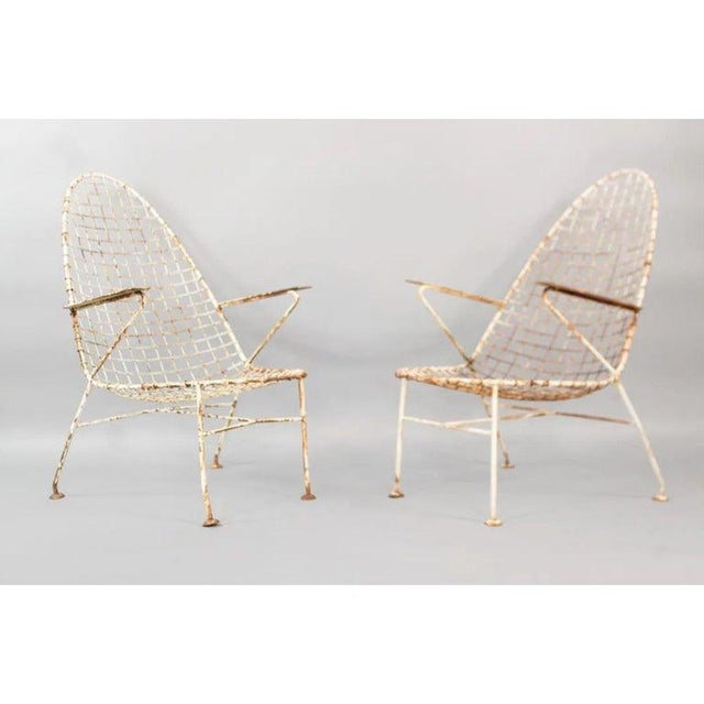 A striking set of four mid-century wire lounge chairs with tall backs and a relaxed, sling-style form. The shape feels...