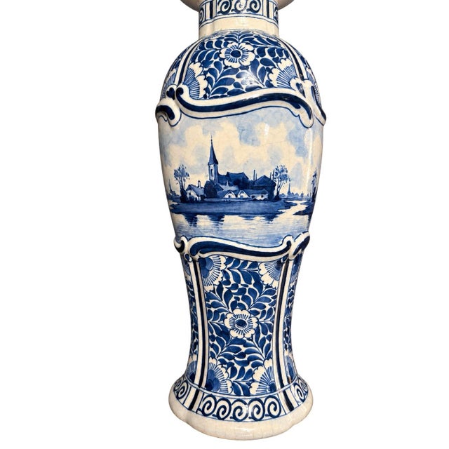 An elegant antique blue-and-white covered vase made in 1911 by De Porceleyne Fles, the historic Dutch manufactory now...