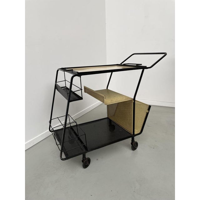 Old service of the 50s in black lacquered metal, perforated metal trays and high metal and yellow formica tray. this cart,...