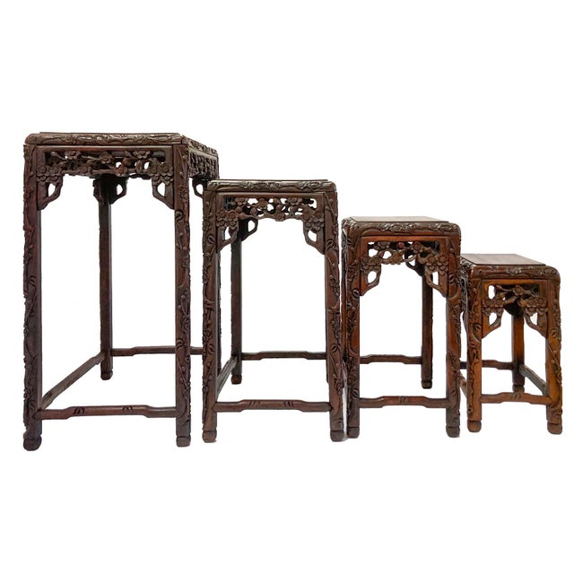 A set of four Chinese hand‑carved rosewood nesting tables, each crafted with a shapely hand carved apron & is supported by...