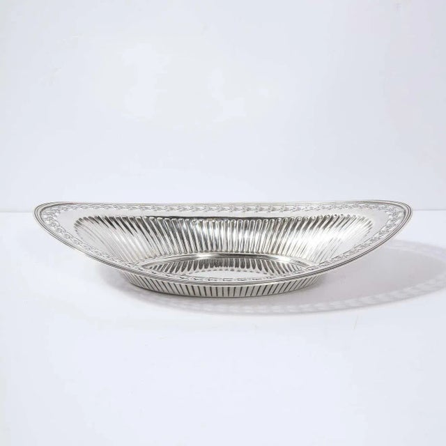 This refined neoclassical style tray features an oval base with undulating channeled sides and a banded exterior edge....