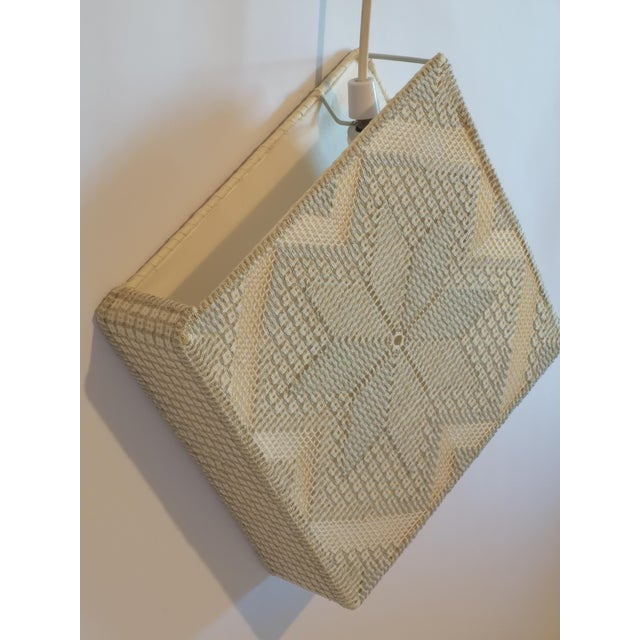 A hand-worked embroidery fabric wall light designed and produced in Sweden, 1960s. The square panel carries a geometric...