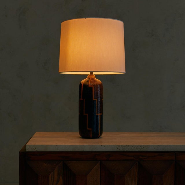A ceramic table lamp from Torino, Italy, dating to the 1990s. The cylindrical body is hand-glazed in a palette of deep...