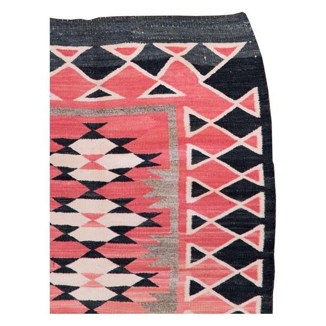 A vintage American flatweave throw rug handmade by the Navajo tribe during the mid-20th century. Measures: 2' 7" x 4' 5".