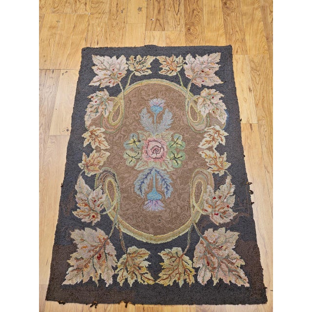 This distinctive Vintage American hand-hooked rug, crafted in the early 1900s in the New England region, is a beautiful...