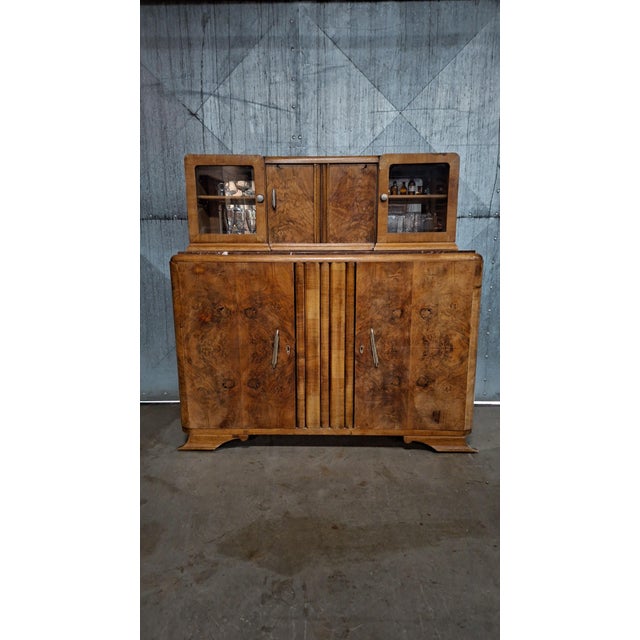 This Art Deco bar cabinet from the 1930s is an elegant piece made from walnut burl wood. The rich grain, rounded shapes...