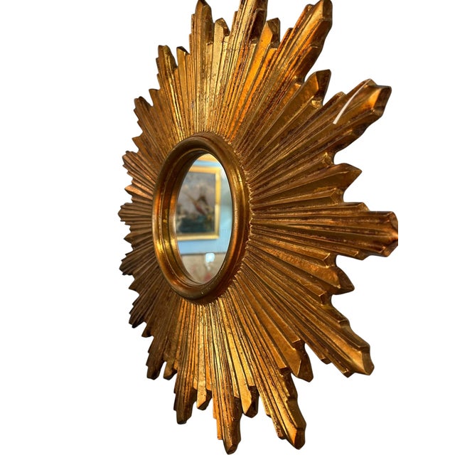 French wood starburst mirror, a striking decorative wall piece with radiating carved wood rays and a warm aged finish. The...