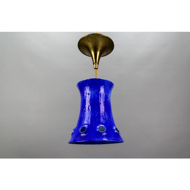 Mid-Century Modern blue enameled iron pendant light fixture from circa the 1960s. This beautiful hanging lamp features an...