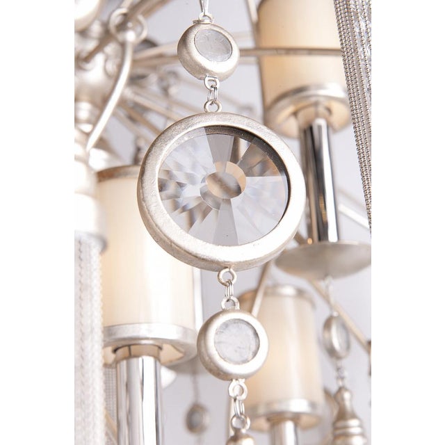 A dramatic starburst chandelier by Corbett Lighting, model Eight + One Light Pendant. The sculptural iron frame is...