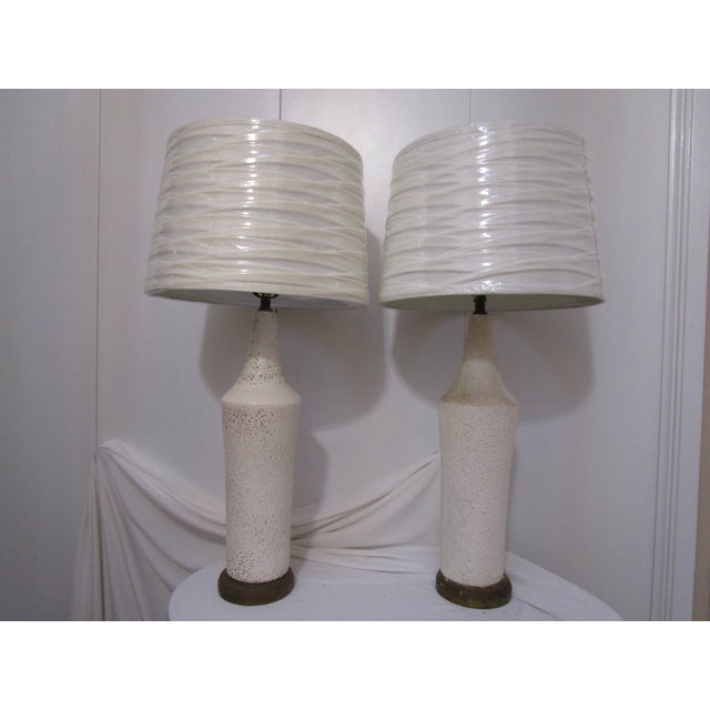 A refined pair of mid-century modern plaster table lamps dating to the 1950s–1960s. The lamps feature tall, sculptural...