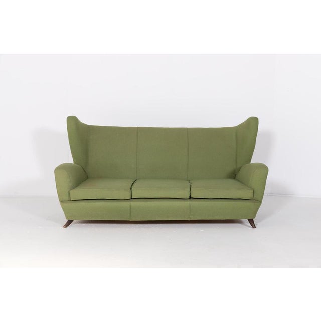 Italian Modern sculptural sofa designed in 1950’s by Paolo Buffa. It features green fabric upholstery, loose seat...