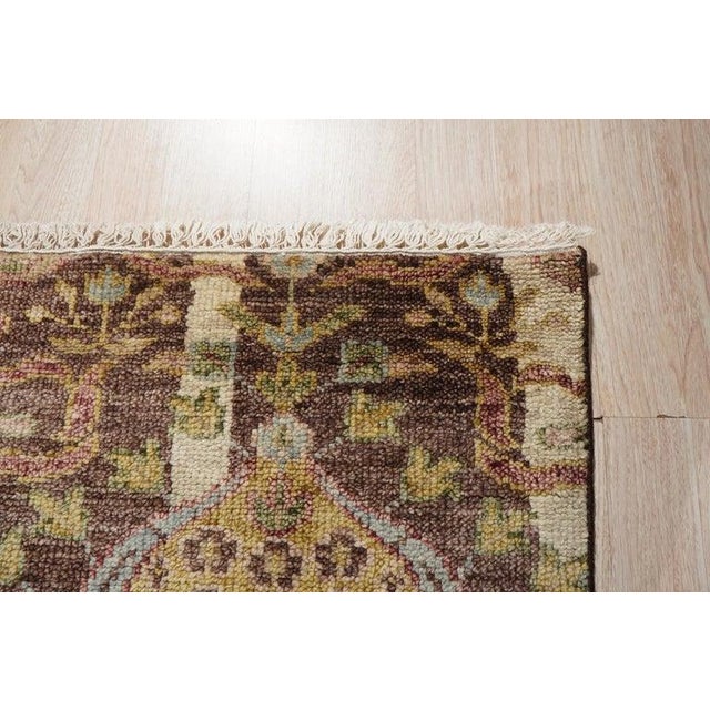 This hand knotted pile rug features a brown earth tone palette and is crafted from durable wool. Modeled after the...