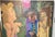 A large figurative painting with an enigmatic, open-ended narrative: elongated golden figures, a man in a cap and tie, and...