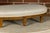 A French Louis XVI style walnut footstool from the 19th century with custom linen upholstery. This exquisite Louis XVI-...