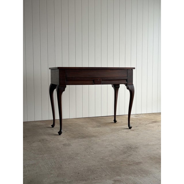 This antique mahogany lift-top writing desk combines the compact footprint of a narrow console table with a surprisingly...