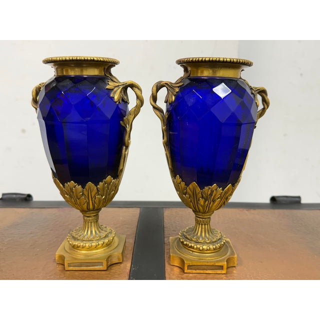 Design Plus Gallery presents a Pair of Gilt Bronze-Mounted Cobalt Blue Vases that are Swedish Neoclassical Style. This...