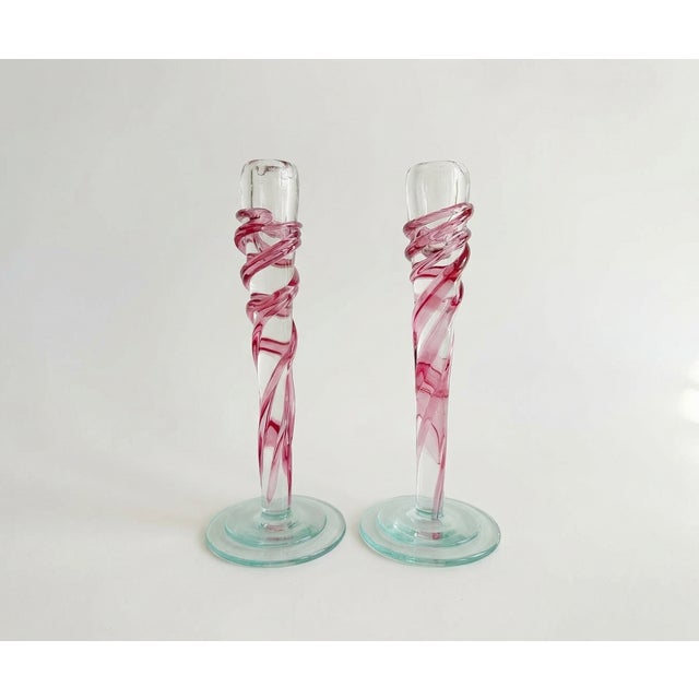 Striking pair of postmodern Italian glass candlestick holders featuring clear glass bodies wrapped in vibrant purple swirl...