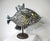 A unique Folk Art metal fish sculpture made of flatware consisting of spoons, knifes and other pieces of metal creating...
