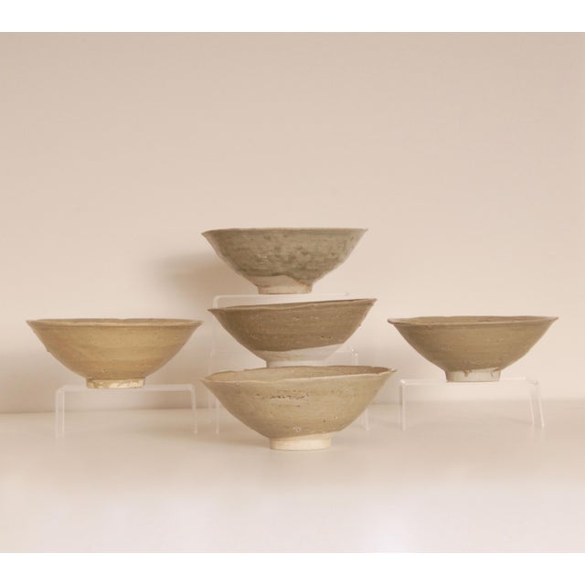 5 Chinese Song Dynasty Celadon Bowls from the Jepara Wreck. The bowls have a sculpted rim and are swiftly Incised with an...