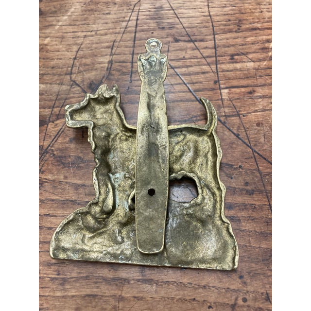 This vintage English brass door knocker, depicting a charming terrier, is a delightful piece of character and...