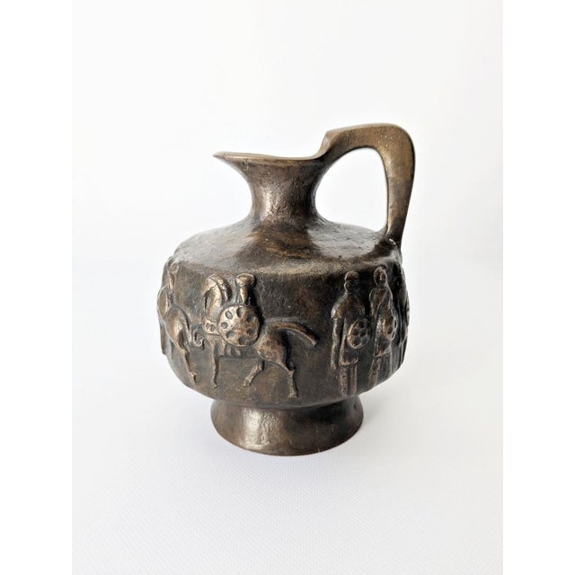 This heavy bronze jug comes from the E. Thelen art foundry and was made in the 1970s. The surrounding relief depicts...