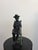 Hand-crafted Maitland-Smith bronze figural sculpture depicting a seated boy playing a flute/recorder, finished with a...