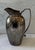 Vintage hammered silver-tone metal water pitcher with a curved handle and flared spout. Heavy in weight. Would be...
