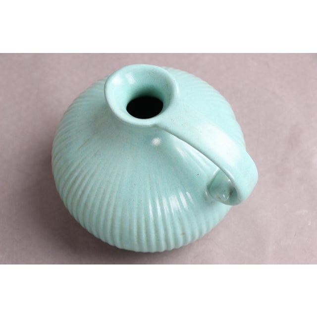 Michael Andersen jug with fluted rim, spout, and handle. Light green/turquoise glaze. The jug is in good condition and...
