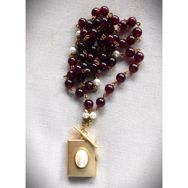 Vintage square four photo locket with white oval bezeled pearl and gold toggle bar, on a 26.0 inch long wine vintage bead...