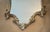 Vintage silver leaf wood framed shield shaped wall mirror. It features carved floral and shell design with other curved...